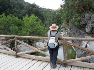 Fototapeta na wymiar Woman with hat doing the Borosa river trail in Cazorla Natural Park