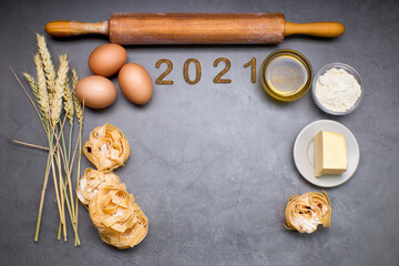 Symbol from number 2021 on a slate with products to make pasta