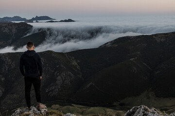 Fototapeta premium Ginger bearded man staring at the horizon during a sunrise in the mountains.