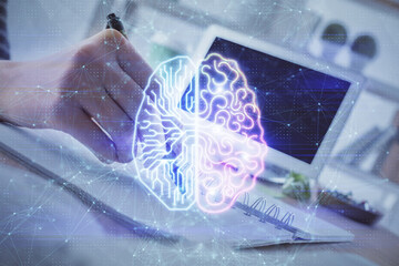 Multi exposure of writing hand on background with brain hologram. Concept of self learning.