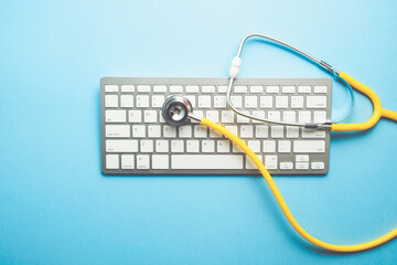 Online doctor concept with stethoscope on keyboard top view.