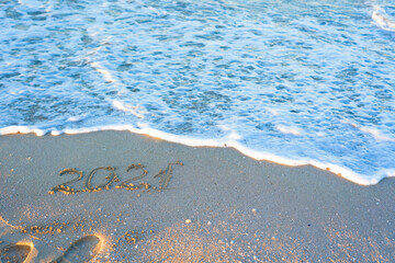 inscription 2021 on the sand on the beach in summer. new year 2021