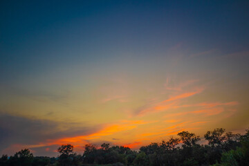 Fototapeta na wymiar beautiful orange cloudy sunset at the fields 