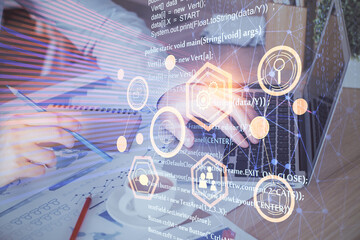 Multi exposure of data internet theme hologram with man working on computer on background. Concept of innovation.