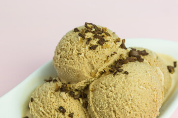fresh coffee ice cream scoops in a bowl with coffee bean pieces