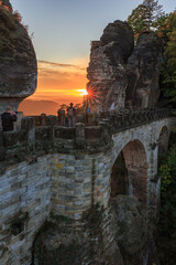 Touristen beobachten den Sonnenuntergang auf der Basteibrücke in der Sächsischen Schweiz
