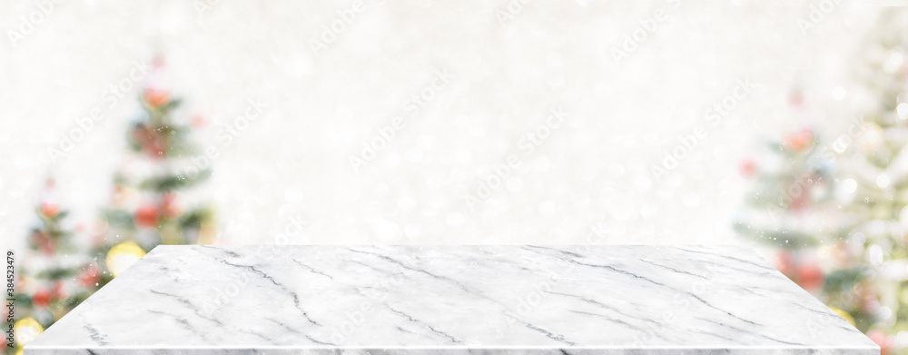 Fototapete perspective marble table with blur christmas tree decorate string light and blue bokeh with snow lig