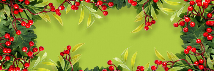 Autumn oak and rowan branches with red berries on green background.