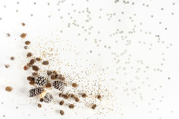 New Year and Christmas background. Pine cones, shining stars and lanterns on white background with copy space