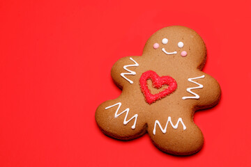 Christmas Gingerbread man biscuit with red heart icing on red background