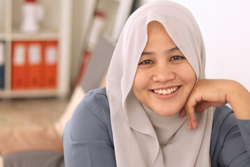 Happy Asian muslim woman smiling cheerful while looking at camera