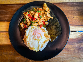 Rice topped with stir-fried chicken and basil with fried egg