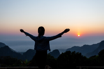 Fototapeta na wymiar Back view of a happy female tourist watching the sunset