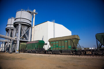 Obraz premium Aktobe province, Kazakhstan - May 04 2019: Phosphate fertilizers plant loading station. Loading hopper. Hopper car train terminal. Green railway carriages.