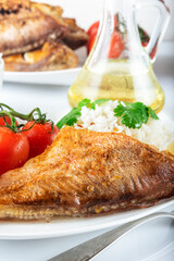 Sea bass grill with rice, greenery and cherry tomatoes. White background.