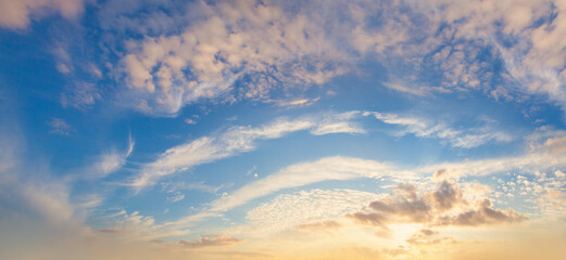 Sunset sky panorama with white clouds and sunlight