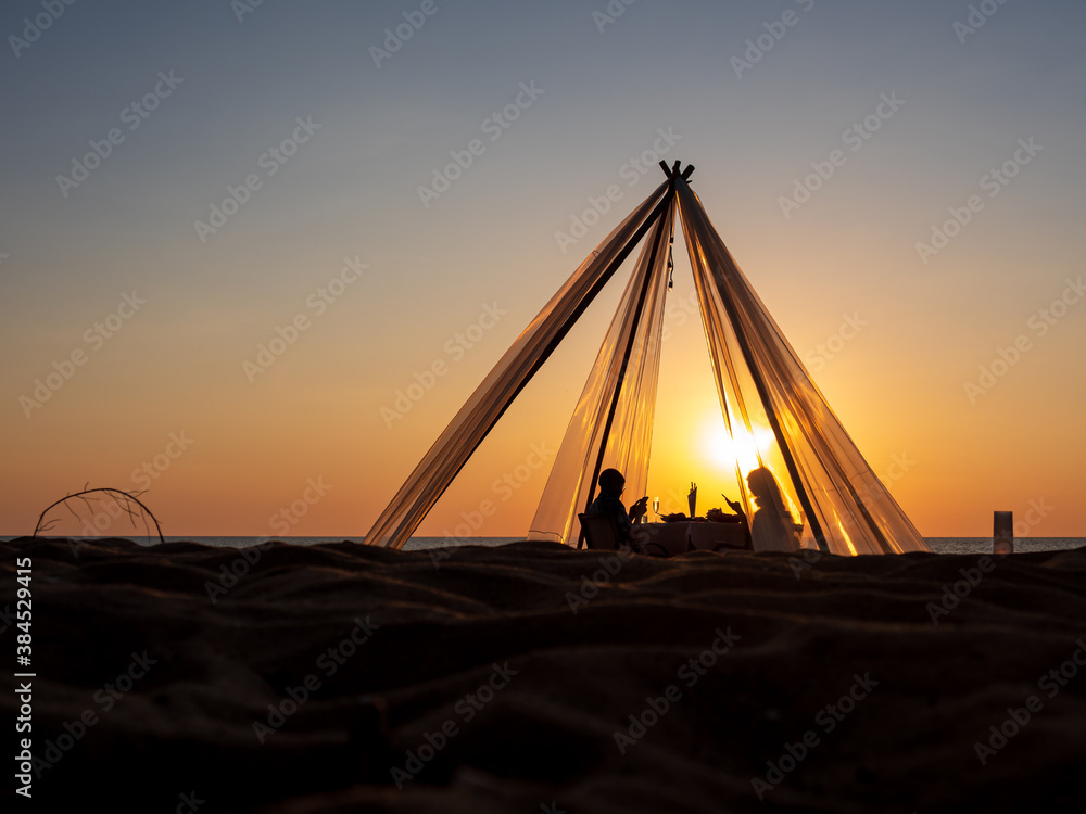 Wall mural Couple on the beach having a dinner