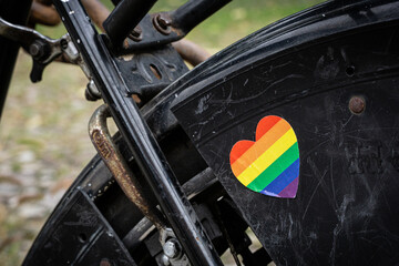 Rainbow sticker in shape of a heart on old black bicycle