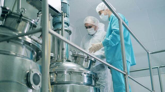 Two male medical workers operating boilers