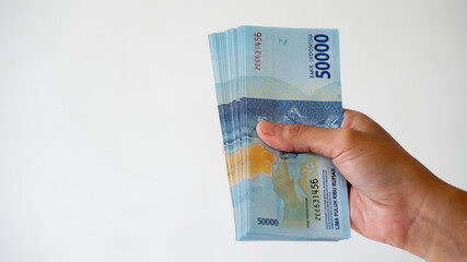Indonesian rupiah currency, around 50,000 Indonesian money, is held by women's hands