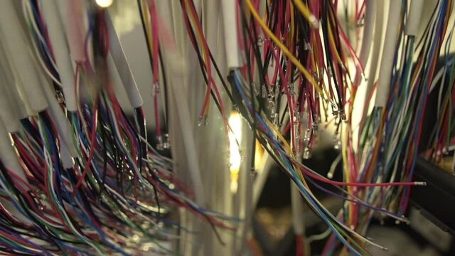 Slow Motion Around Bundles of Colored Wires Hanging in the Workshop. DIY project electronics. Wires jumpers for mockup prototype breadboard plate.