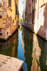 Picturesque view between the canals of Venice with blurred object in the foreground, Veneto - Italy
