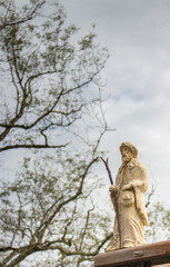 Small statue of Saint James on Camino de Santiago. Pilgrimage concept. Main christian saint of pilgrims. Ancient sculpture of Saint James in Pyrenees mountains, France. Religious architecture. 