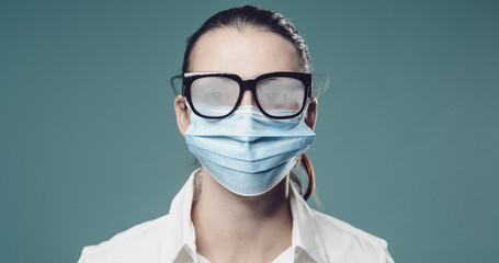 Woman wearing a surgical mask and fogged up glasses