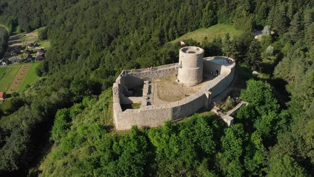 Flying over medieval castle and view of Poprad river in summer. Beskid Mountains, village Rytro, Poland.