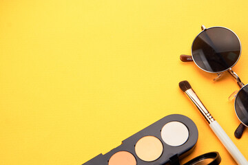 Professional eyeshadows and makeup brushes on a yellow background make-up decoration