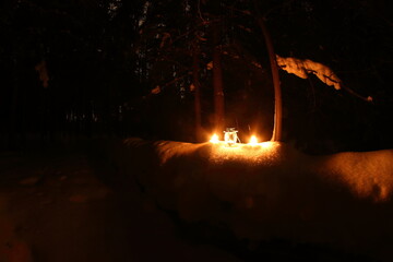candles lit in the forest on the snow