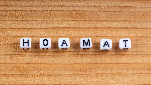 Close-up of wooden blocks spelling Hoamat meaning home in Bavarian dialect on wood texture.