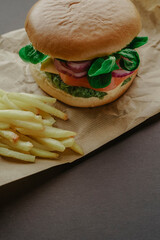 Healthy vegan spinach, tomato, arugula, onion and cheese green burger with potatoes 