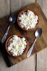 Selective focus. Fresh granular cottage cheese in bowls. Rustic style.