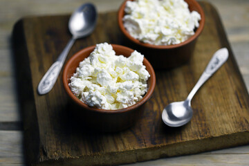 Selective focus. Fresh granular cottage cheese in bowls. Rustic style.