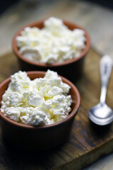 Selective focus. Fresh granular cottage cheese in bowls. Rustic style.