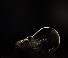 Incandescent light Incandescent light bulb with tungsten filament on a black background.