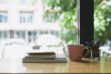 Hot coffee on wooden desk with notebook.