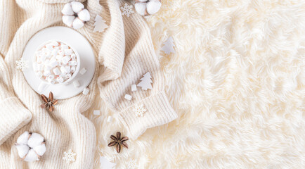 Fototapeta na wymiar Winter composition. Gift box marshmallow cup, Christmas ball snowflakes, anise stars, beige sweater on cream colour knitted blanket and fluffy background. Flat lay top view copy space.
