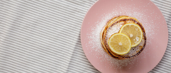 Homemade Lemon Ricotta Pancakes on a pink plate, top view. Flat lay, overhead, from above. Space for text.