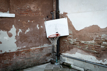 worn basket ball hoop hanging low in streets of venice
