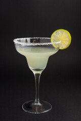 margarita cocktail with lime on dark background.