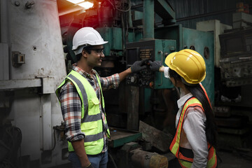 Engineer train new lady employee in industrial factory about machine repair and maintenance