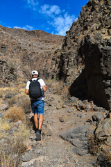 Latin American tourist photographing a mountain landscape.