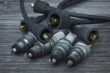 Old used spark plugs and high voltage cables for engine. Condition after years of usage and...