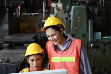 Lady operator talking together and using computer for monitor and control in manufacturing factory