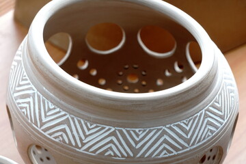 handmade unbacked crockery and pots on the table in the potter's studio. clay before firing in a ceramic kiln