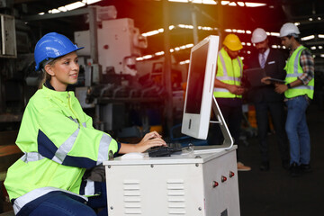 Lady engineer or worker is working in factory with using computer and radio for operate and...