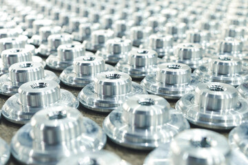 Round metal items neatly folded in even rows going into the distance out of focus. Metal parts...