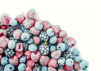 Various frozen berries in corner of white. Blueberry, blackberry and raspberry. With copy space